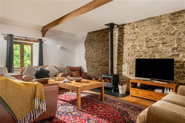 Corn Barn lounge with sofas, coffee table, log burner and T.V.